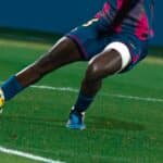 Joueuse de football attaquante, en plein élan, prête à tirer un frappe en direction des buts