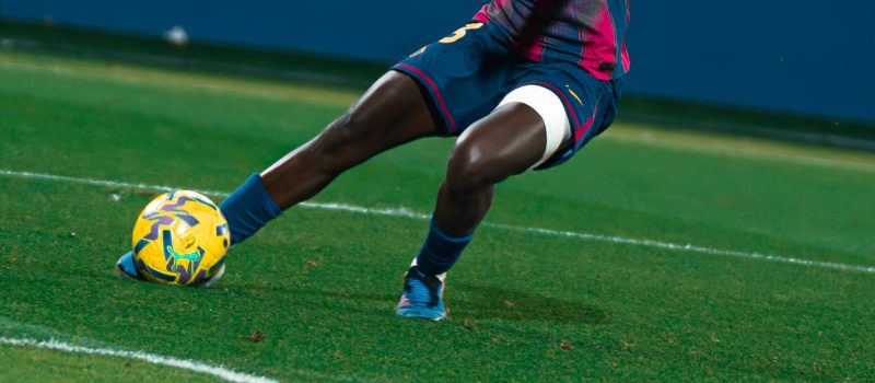 Joueuse de football attaquante, en plein élan, prête à tirer un frappe en direction des buts